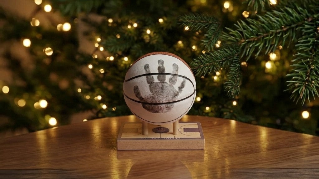 Baby's first Christmas handprint keepsake on a display-quality basketball, mounted on a maple display base.