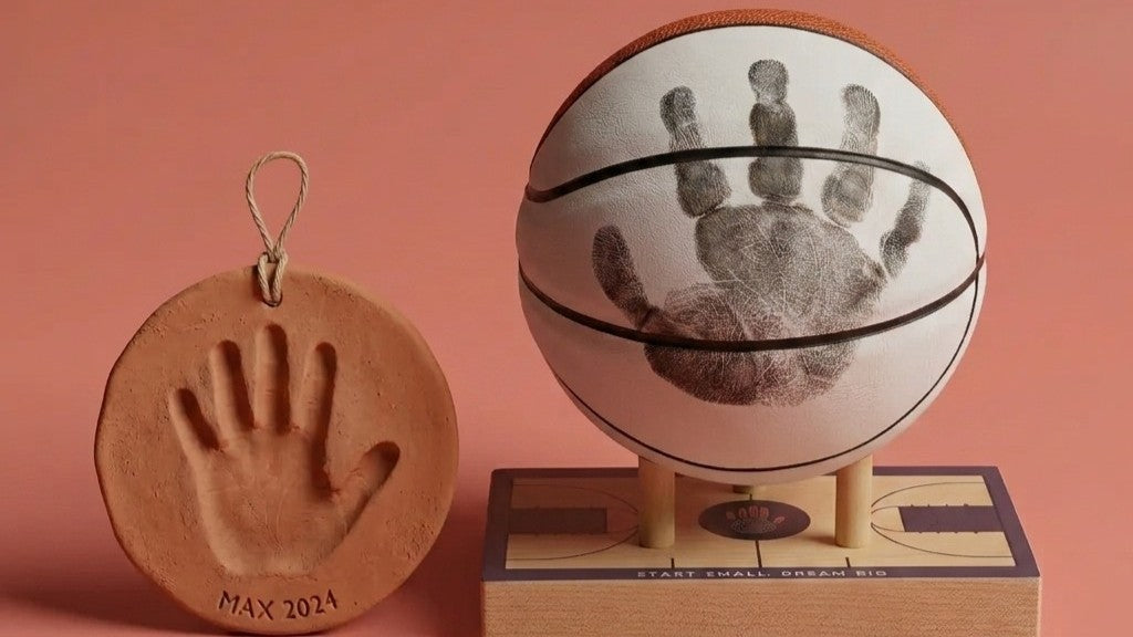 Ink pad handprint on a display-quality basketball beside a cracked clay handprint disc