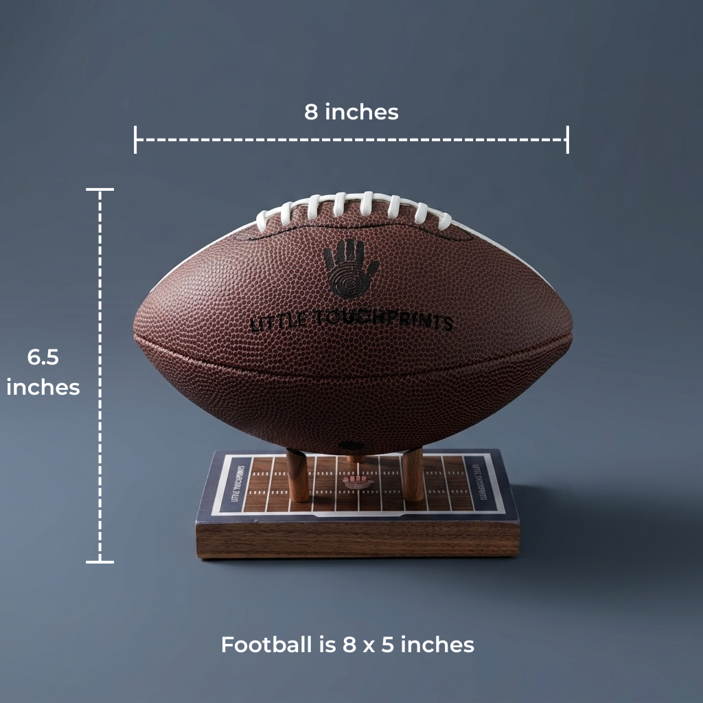 A brown football on a wooden display stand with measurement labels showing 8 inches width, 6.5 inches height, and a note that the football is 8 x 5 inches, on a dark gray background.